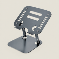 Grey adjustable laptop stand with a ventilated metal platform, non-slip pads and a stable base for ergonomic desk use.