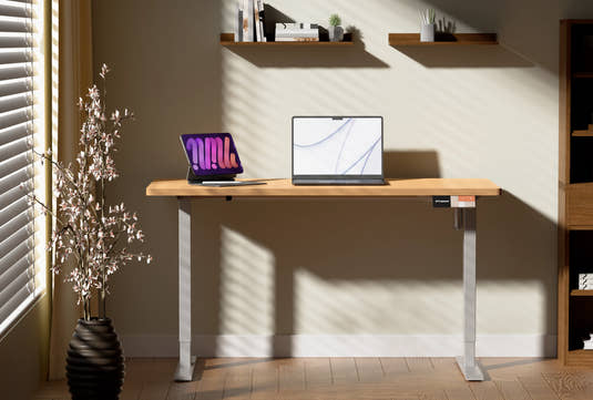 Shappa MS1 electric standing desk with timber tabletop and white frame in a cosy home office setting