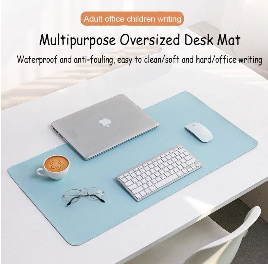 Leather keyboard mat on a desk with a laptop, keyboard, mouse, coffee cup and glasses