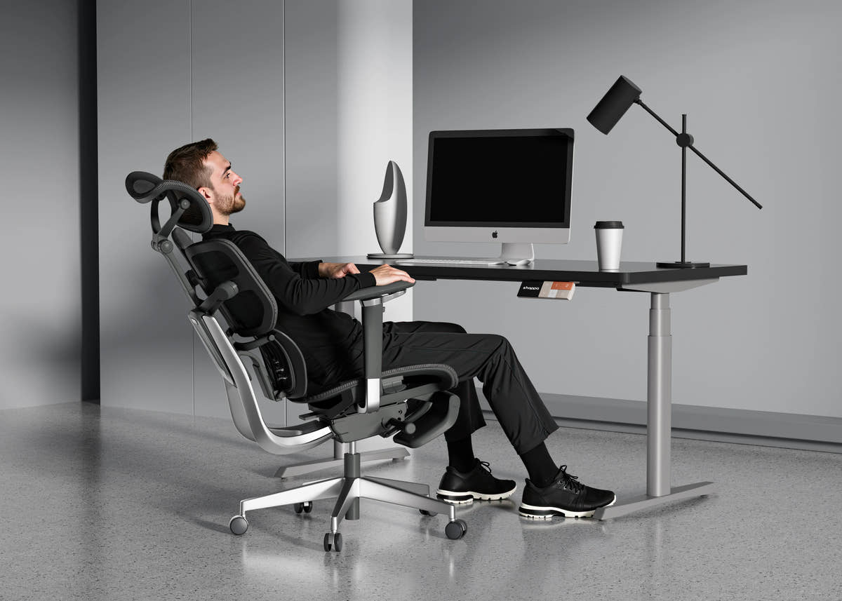 Man reclining in Shappa Spencer black ergonomic office chair for a break at his desk