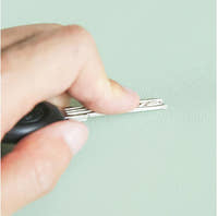 Testing the desk mat's scratch-resistant surface with a metal comb